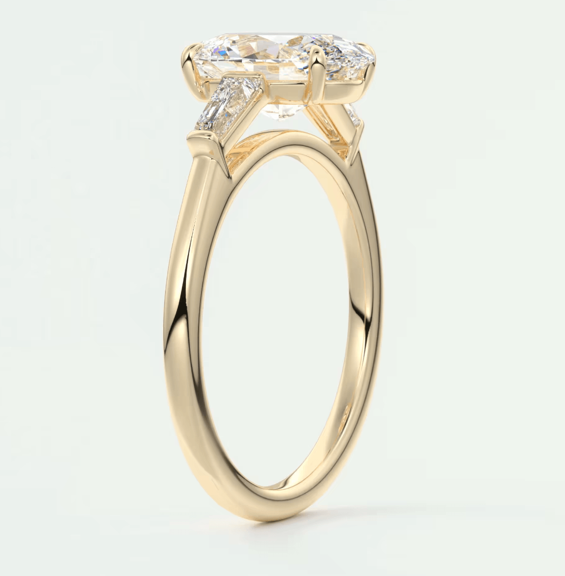 18-karat yellow gold engagement ring with a cushion-cut diamond and two smaller diamonds on each side.