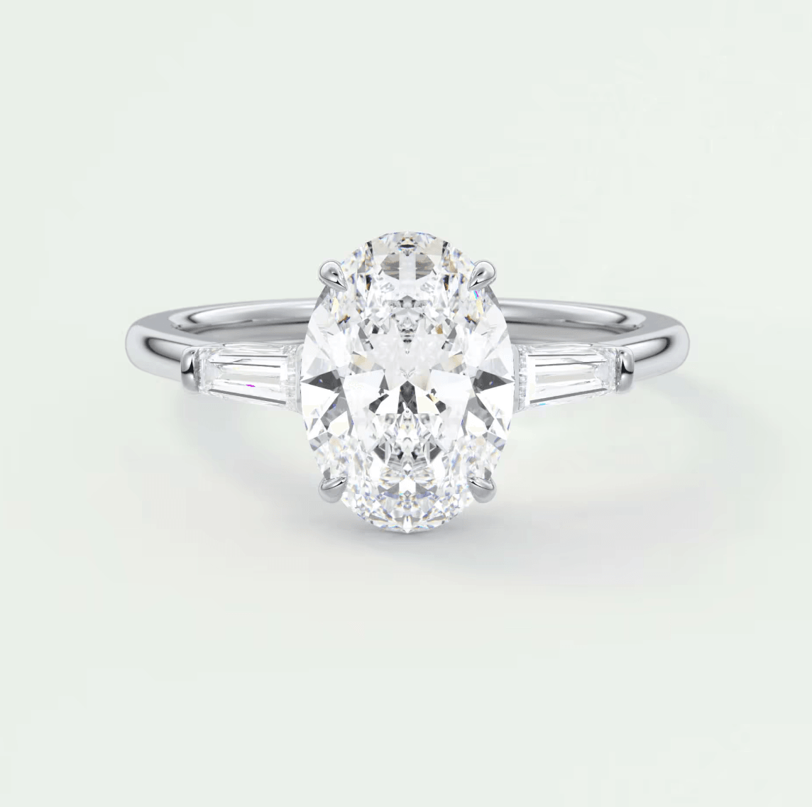 18-karat white gold oval diamond engagement ring with baguette accents.