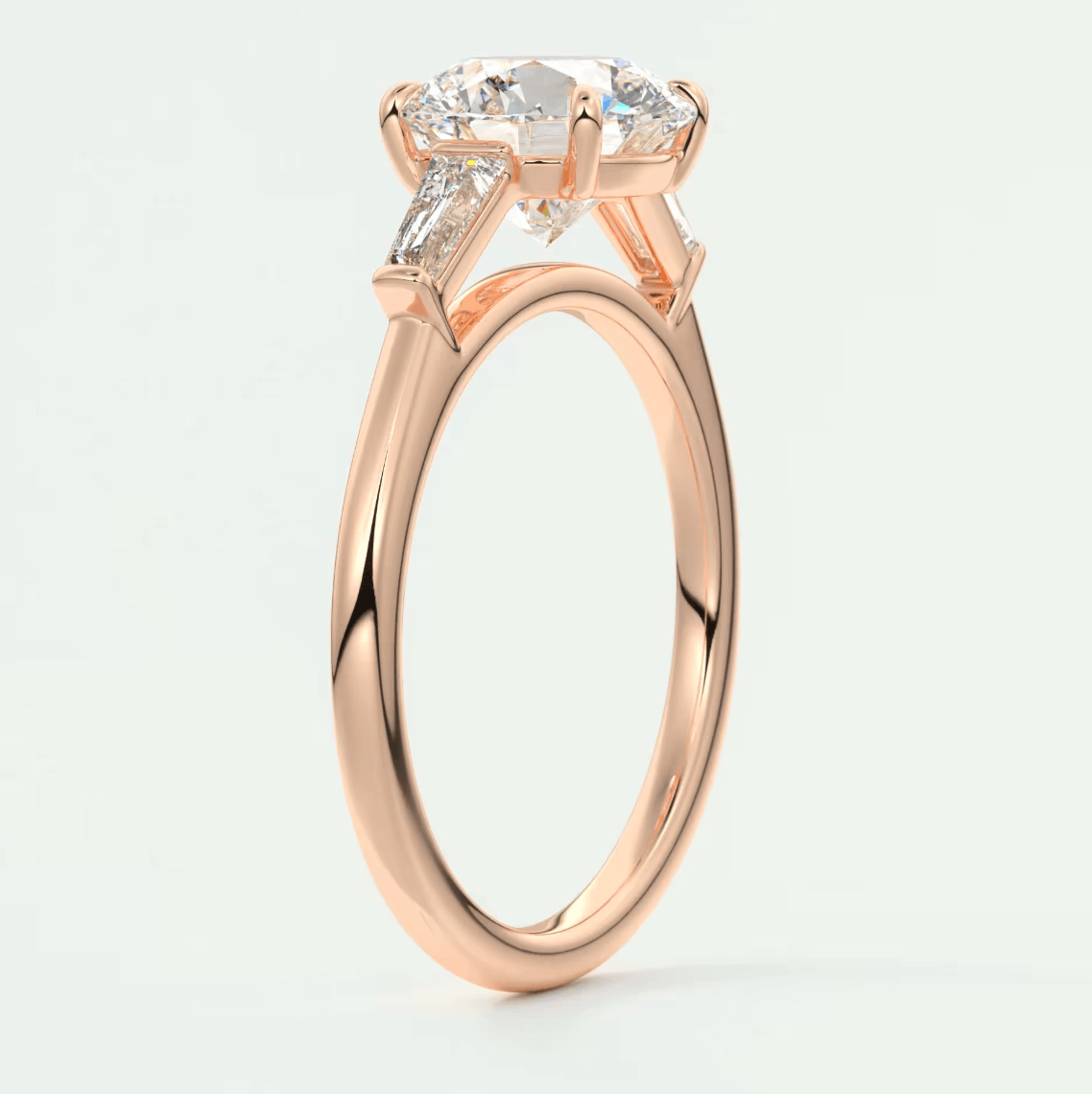 18-karat rose gold engagement ring with a marquise-cut diamond and two smaller diamonds on each side.