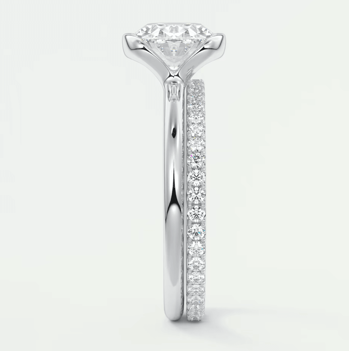 18k white gold diamond engagement ring with a round brilliant cut center stone and pavé set diamonds on the band.