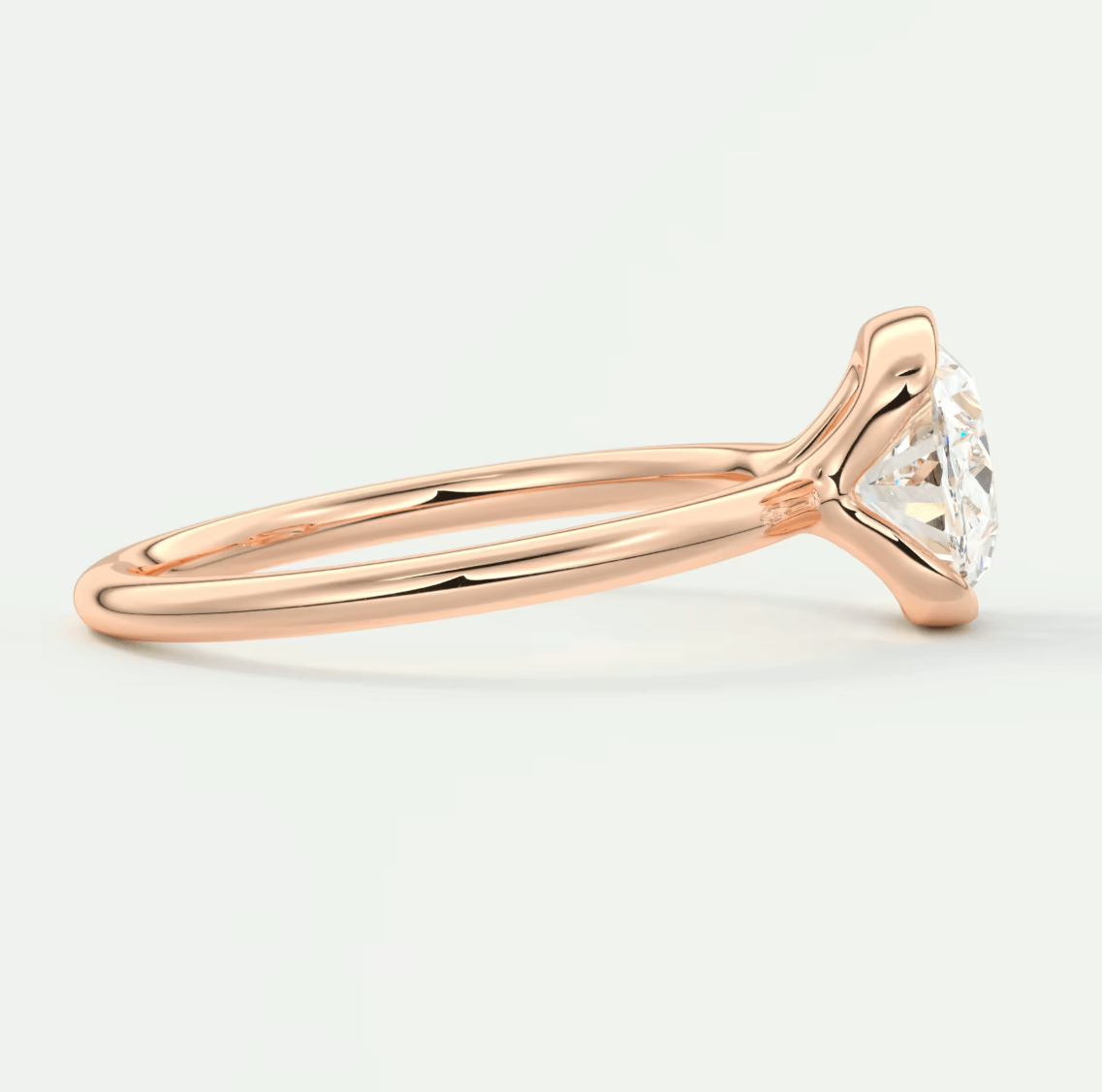 Rose gold diamond engagement ring with a classic solitaire design and cushion-cut gemstone.
