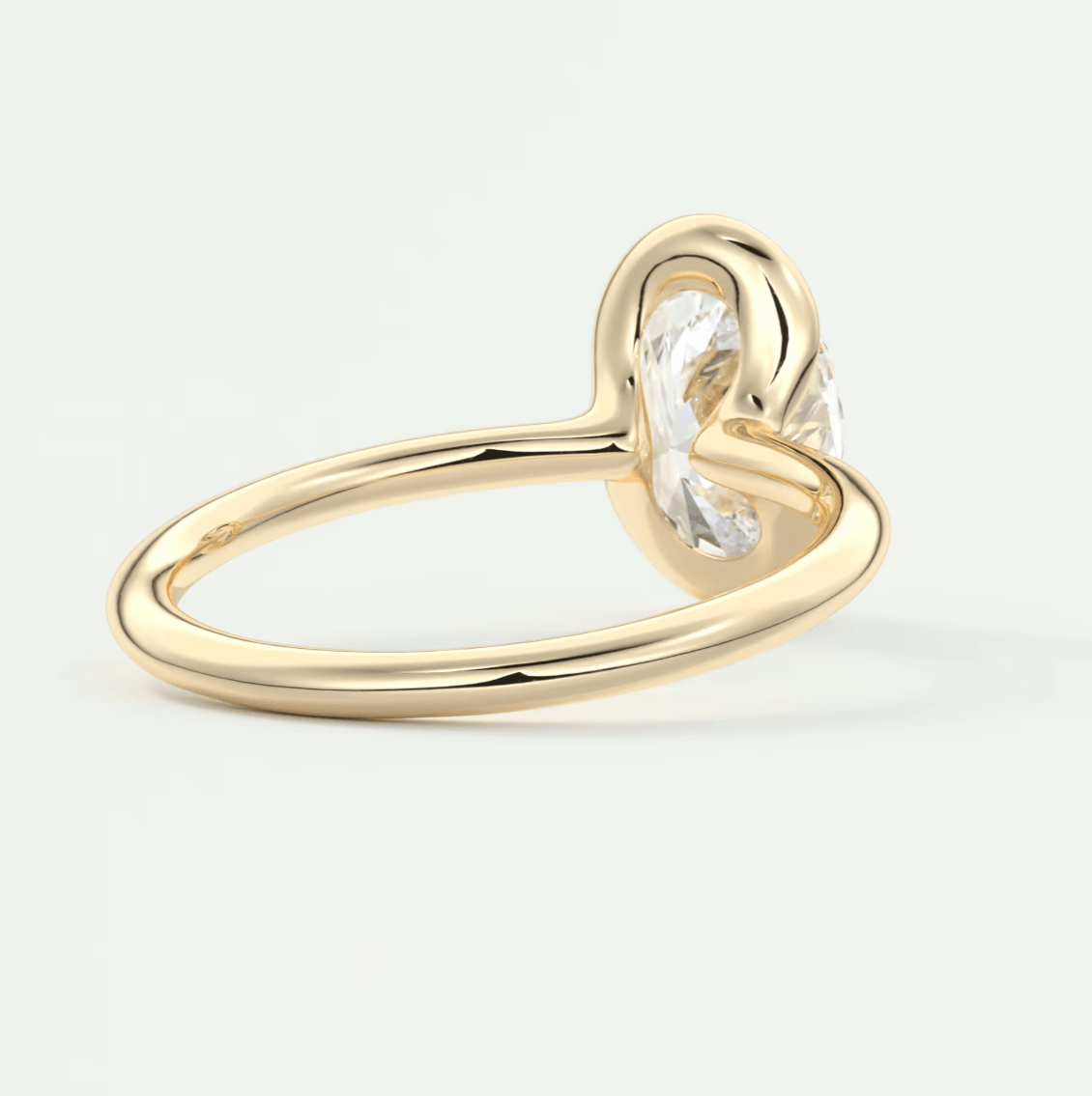 Gold knot ring with a clear gemstone center.