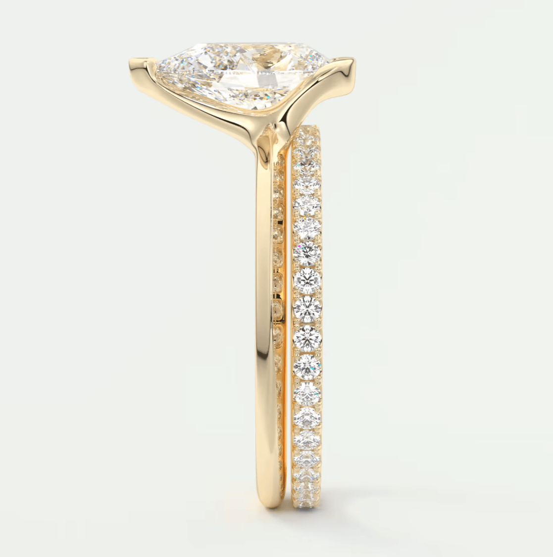 18k gold diamond engagement ring with a pear-shaped center stone and side pavé diamonds.