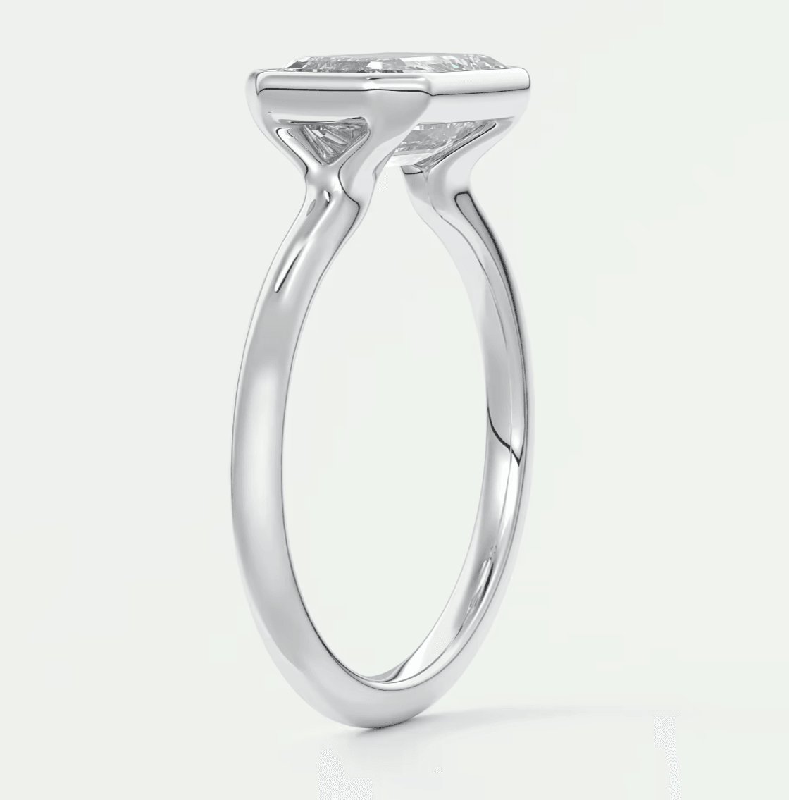White gold solitaire engagement ring with a cushion-cut diamond.