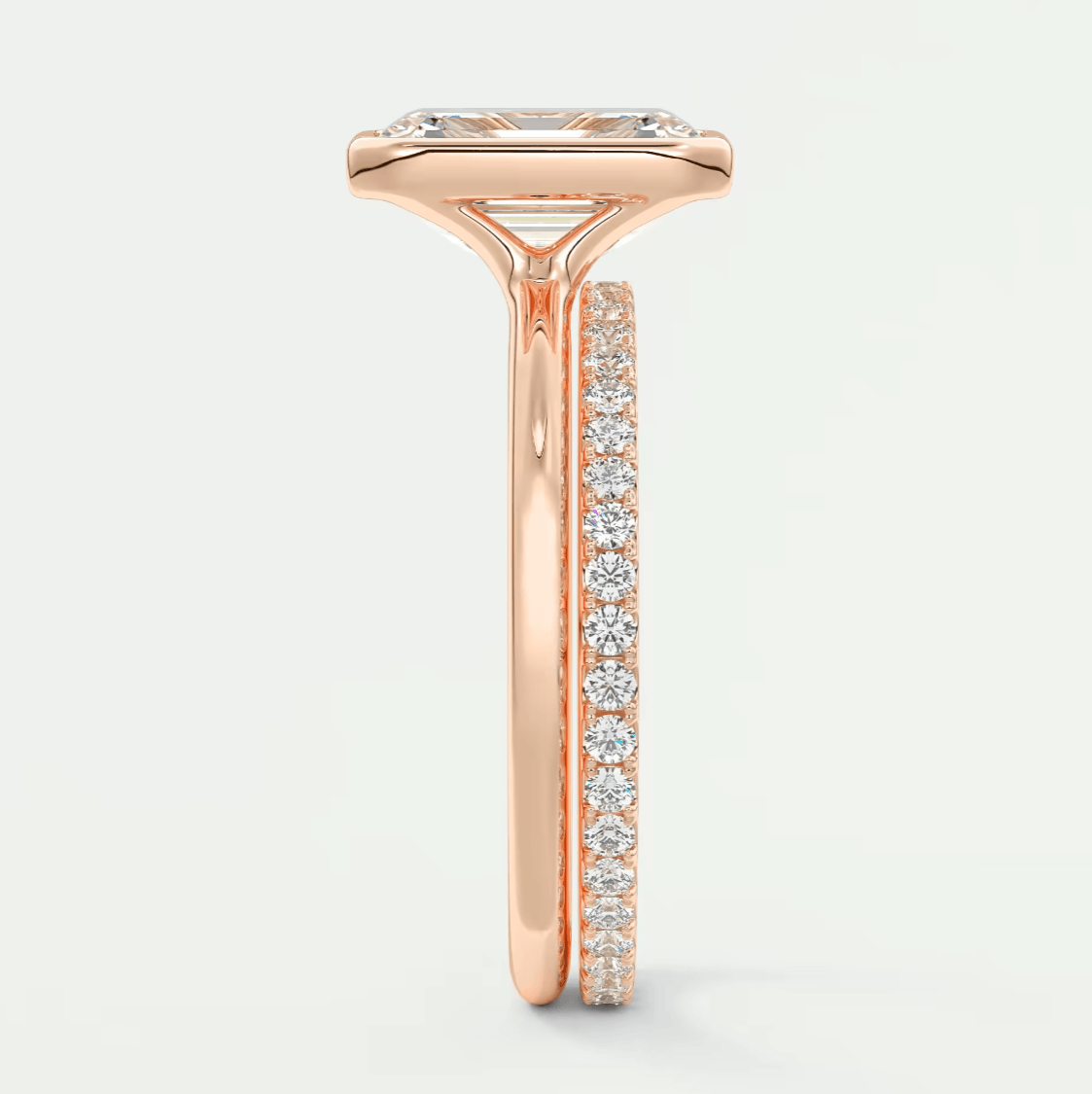 Rose gold diamond engagement ring with a princess cut center stone and channel set side stones.