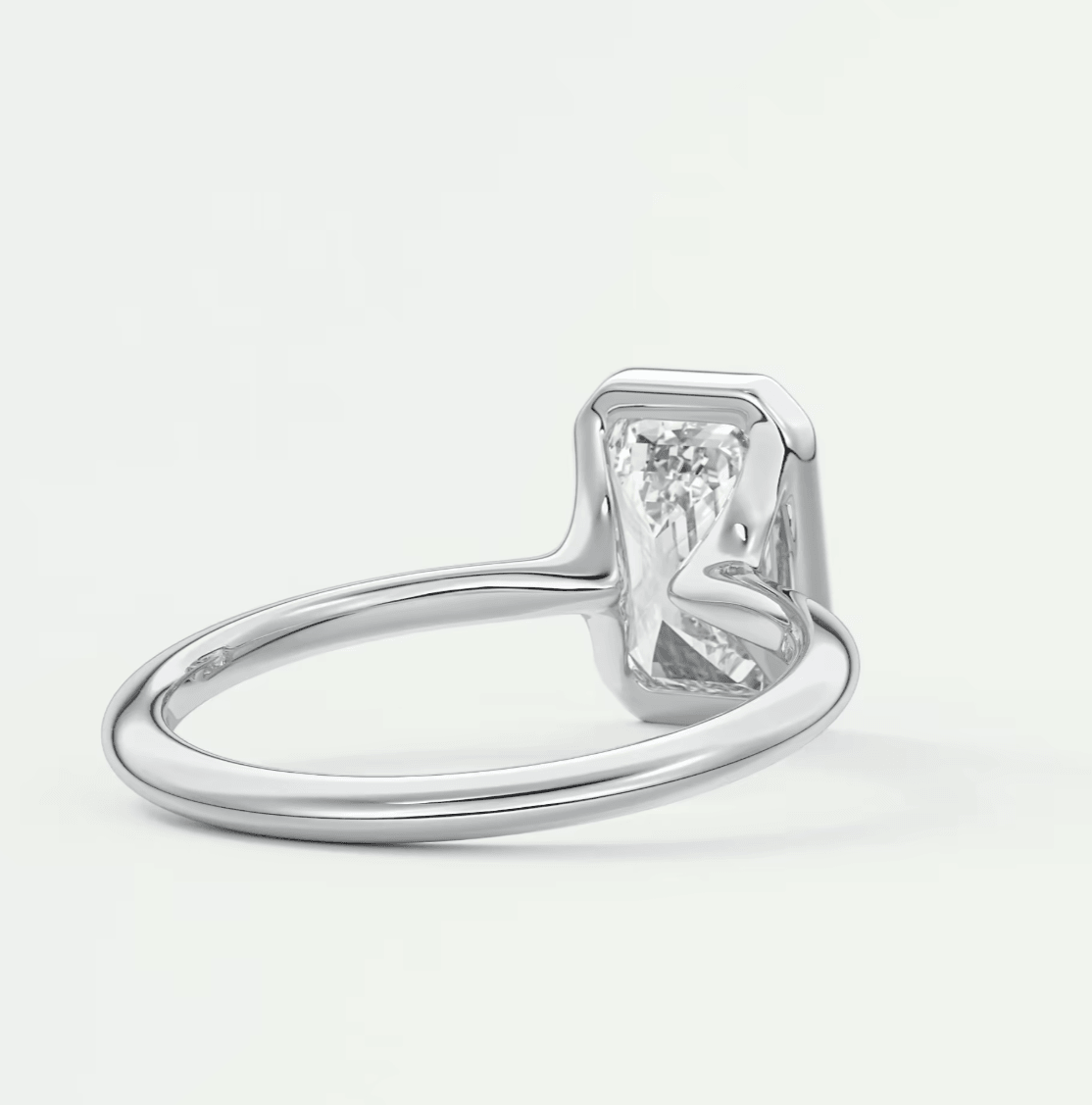 White gold emerald cut diamond engagement ring with a solitaire setting.