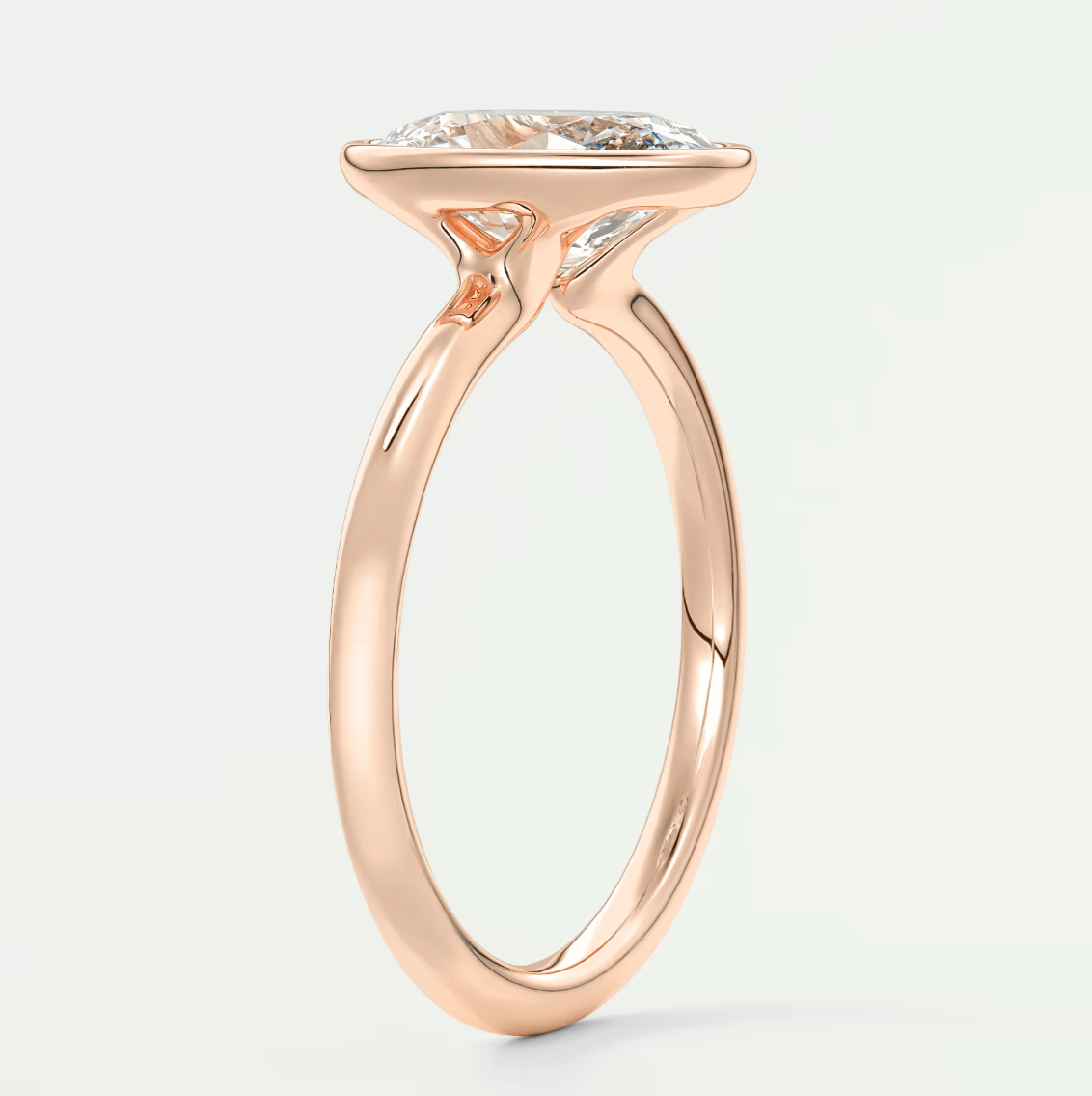 Rose gold marquise diamond engagement ring with a twisted band design.