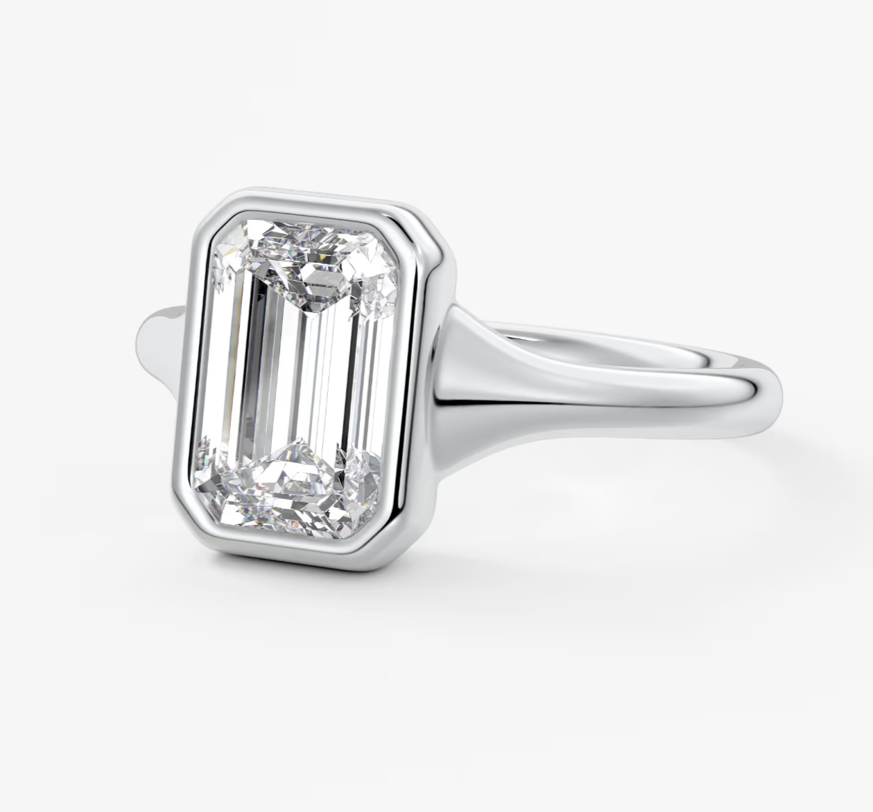 18k white gold diamond engagement ring with an emerald-cut center stone and small round diamonds.