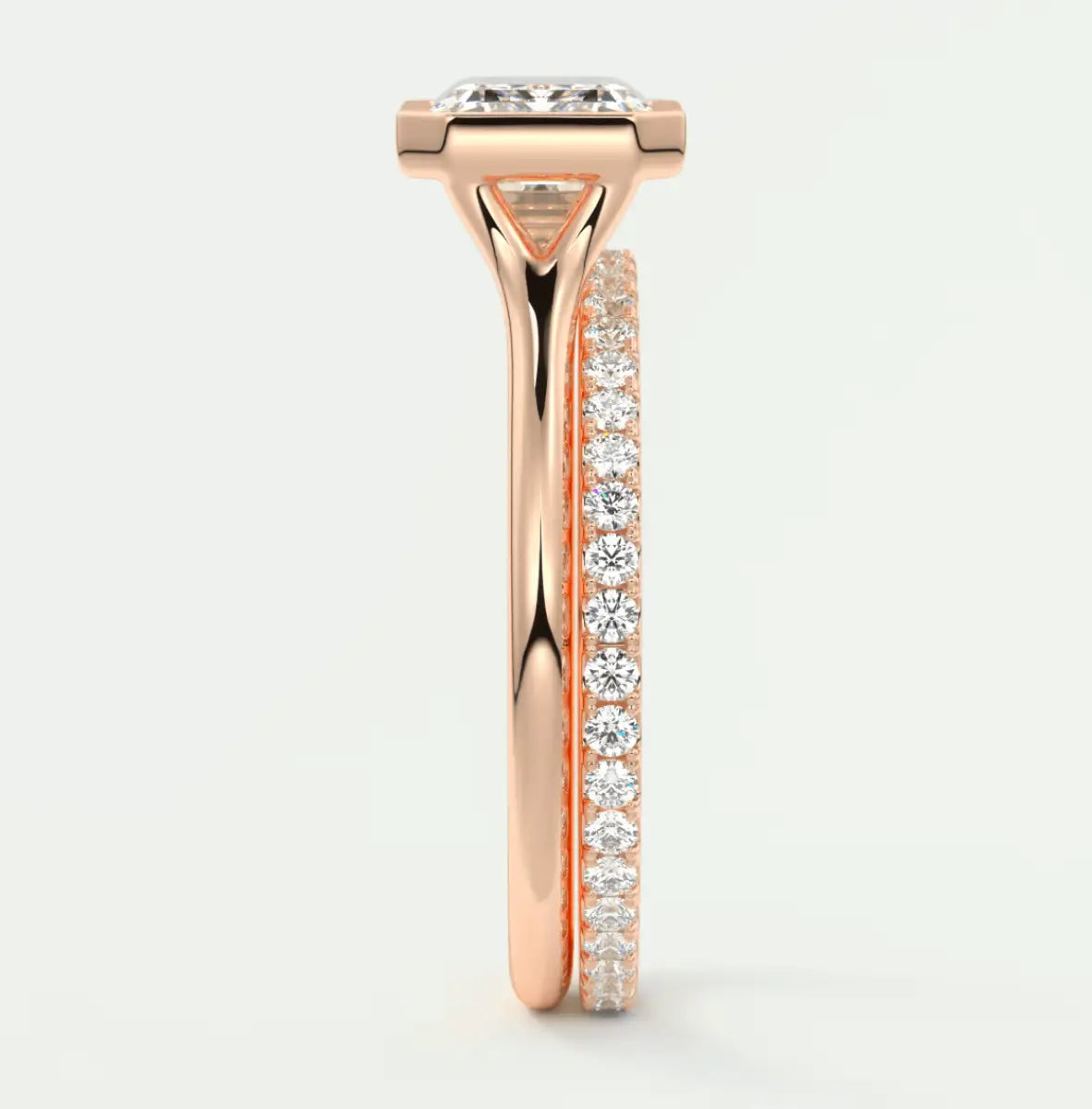 18k rose gold diamond engagement ring with a princess cut center stone and pavé set side stones.