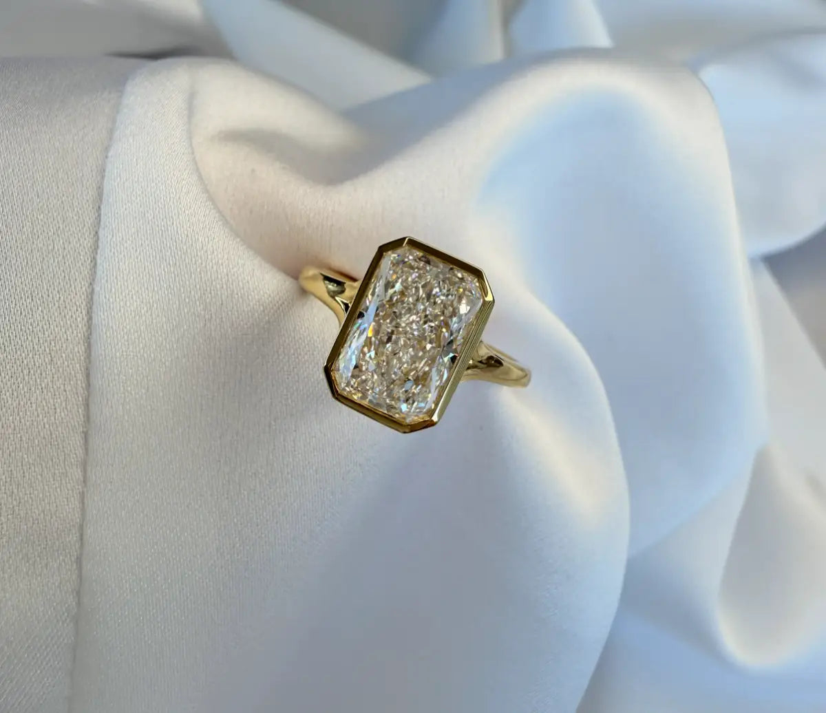Gold ring with a diamond on a white fabric background