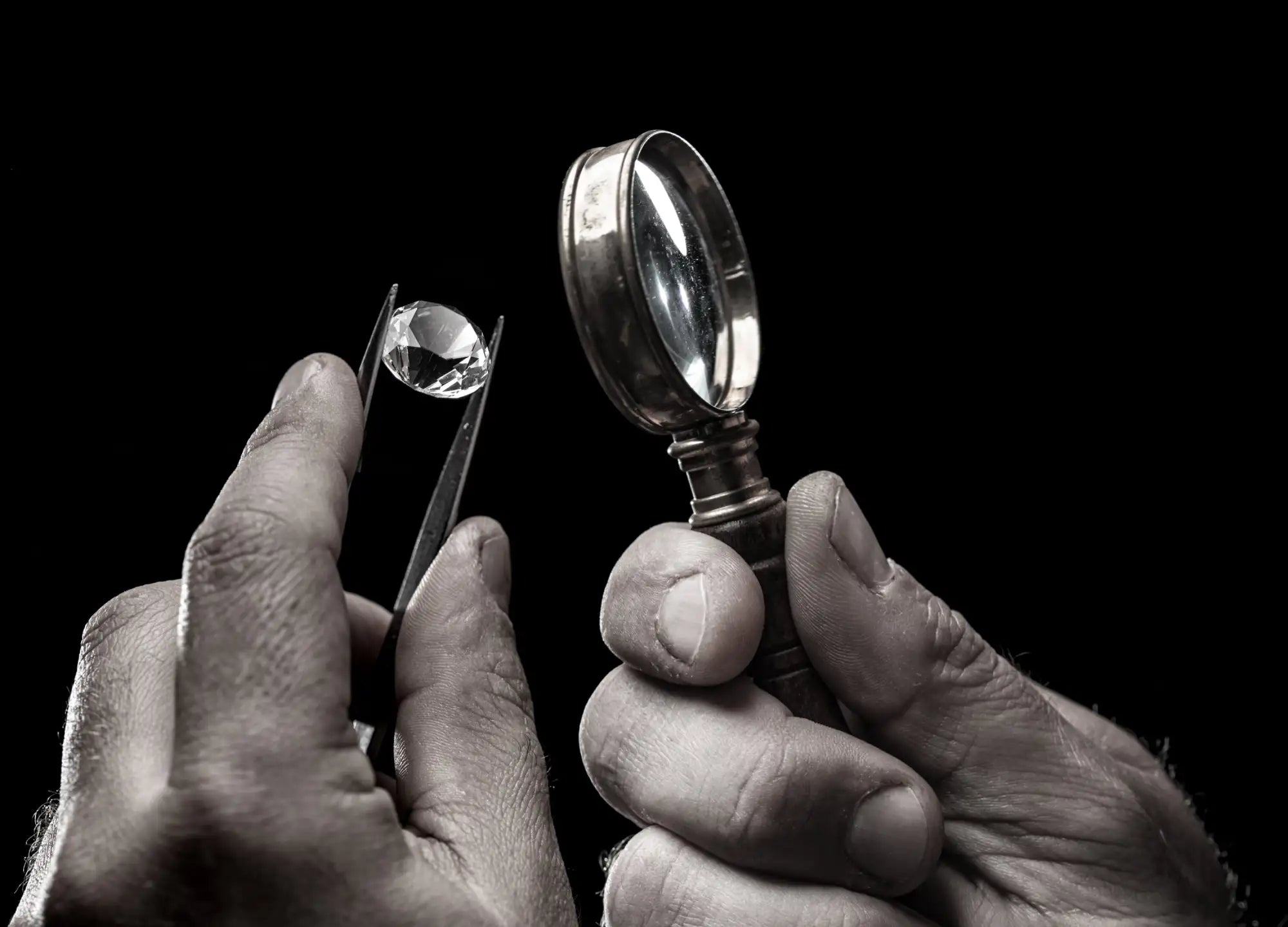 A clear, faceted gemstone held delicately between precision tweezers.