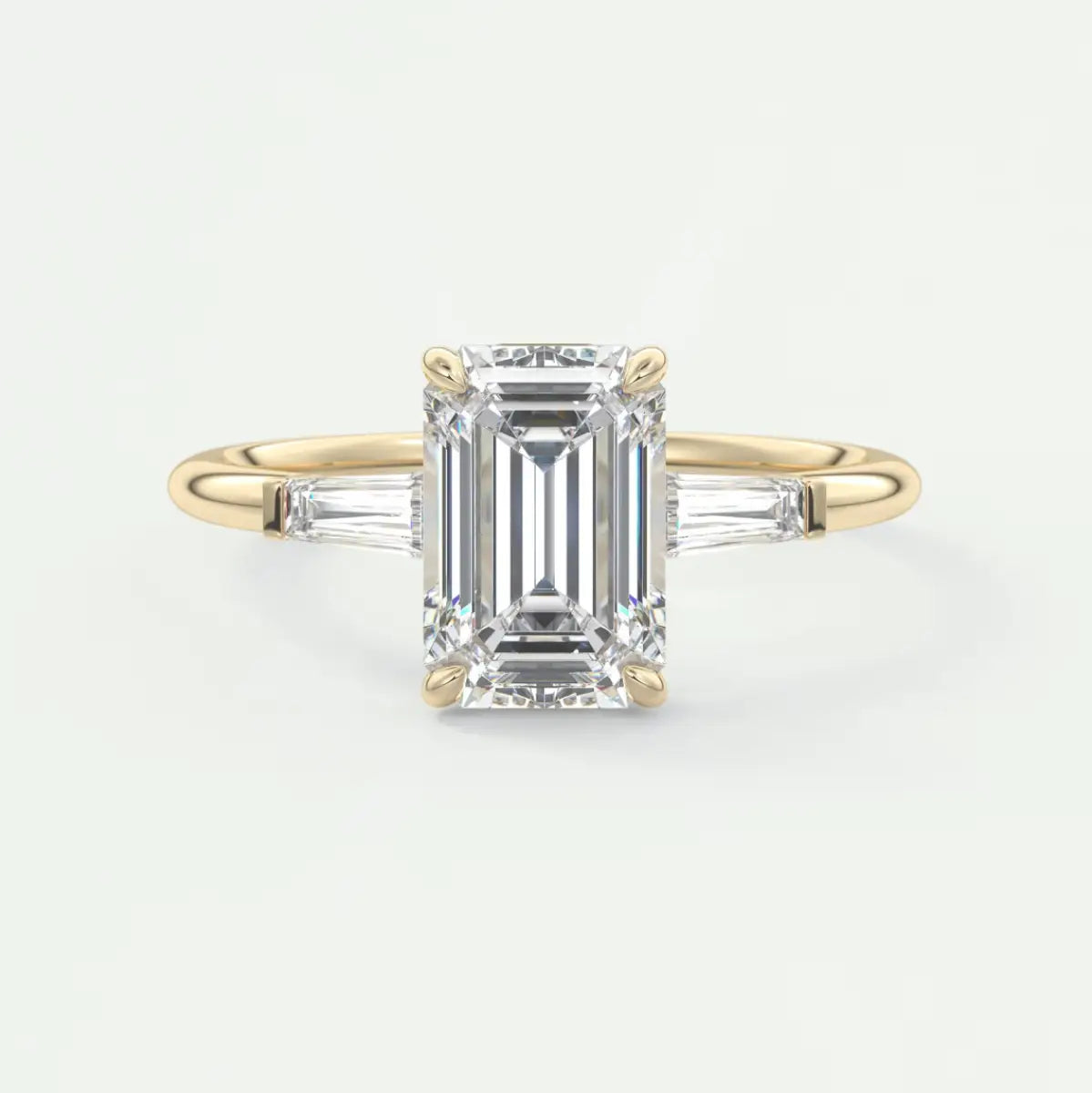 Custom made elysian emerald three-stone engagement ring with tapered baguettes