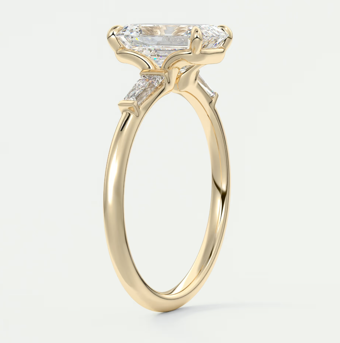 Custom made elysian emerald three-stone engagement ring with tapered baguettes