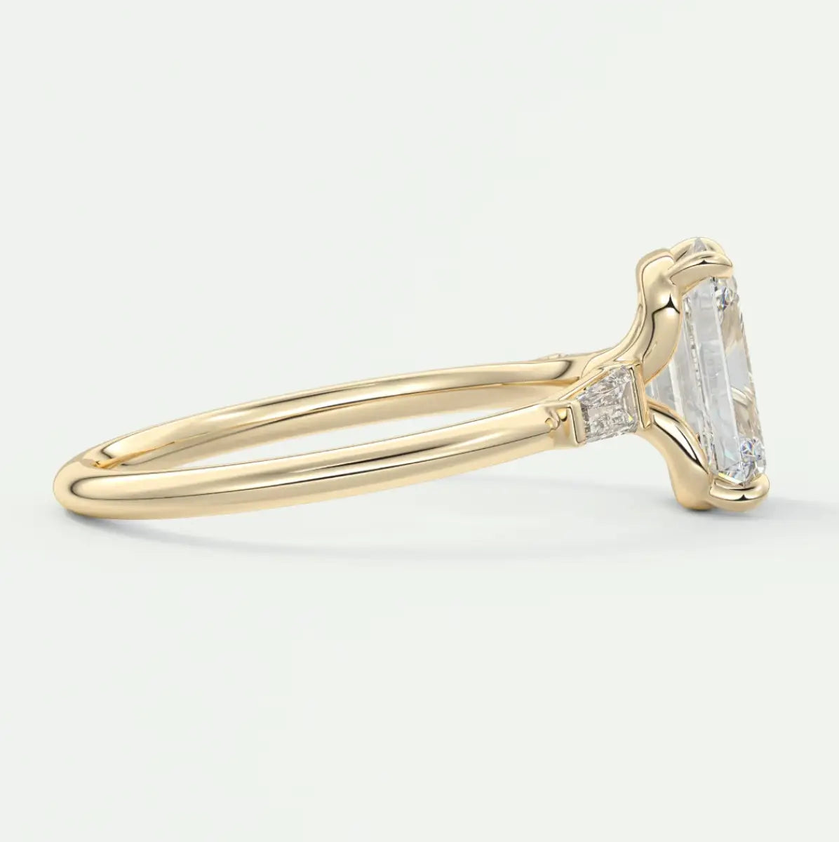 Custom made elysian emerald three-stone engagement ring with tapered baguettes