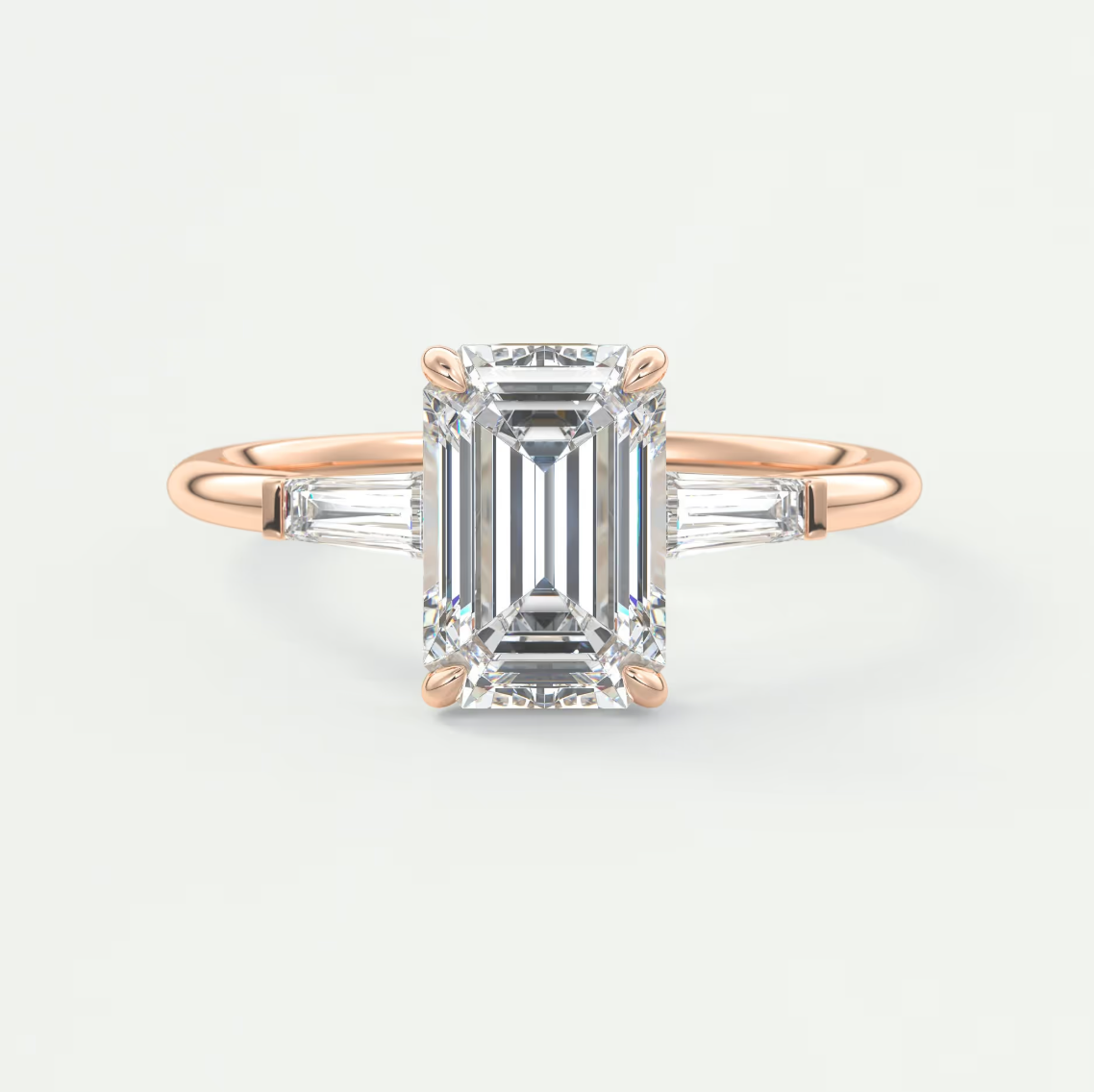 Custom made elysian emerald three-stone engagement ring with tapered baguettes