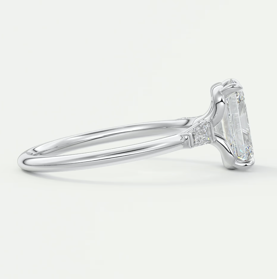 Custom made elysian emerald three-stone engagement ring with tapered baguettes