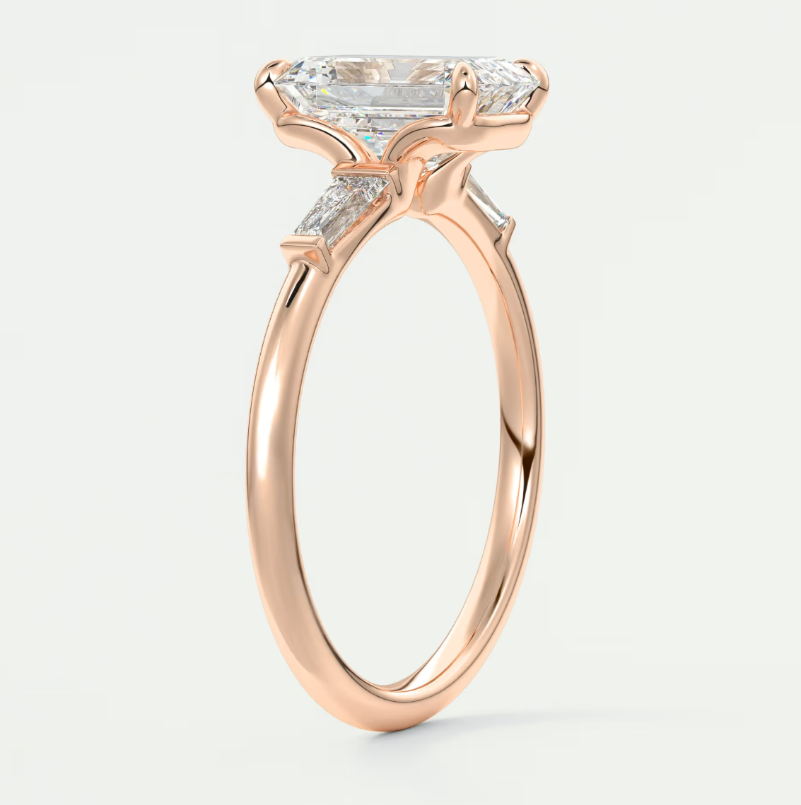 Custom made elysian emerald three-stone engagement ring with tapered baguettes