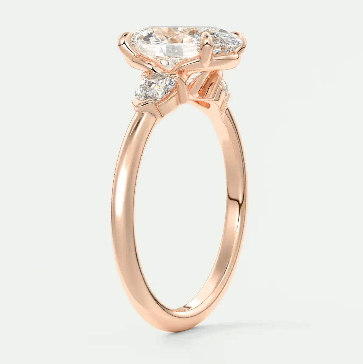 Rose gold engagement ring with a marquise-cut diamond and smaller diamonds on the band, featuring an elegant floral-inspired design.