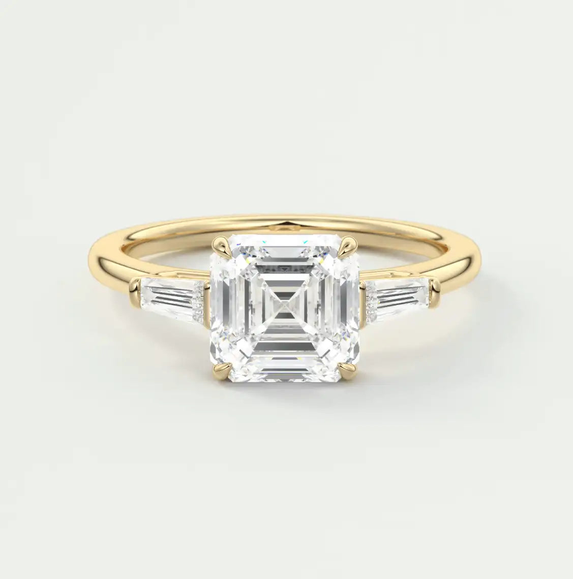 18k yellow gold engagement ring with an asscher-cut diamond and baguette side stones.