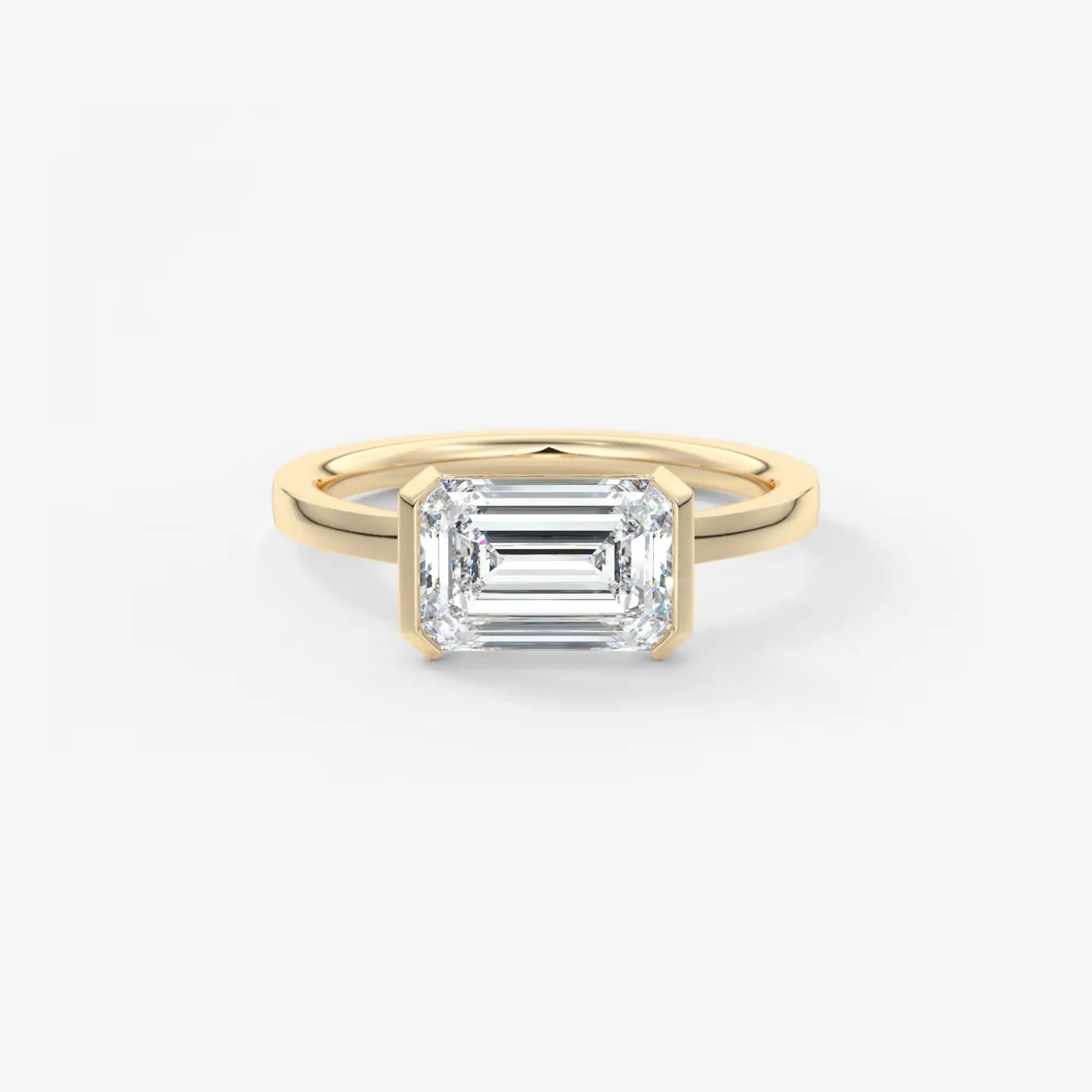 Gold ring with a rectangular diamond on a white background