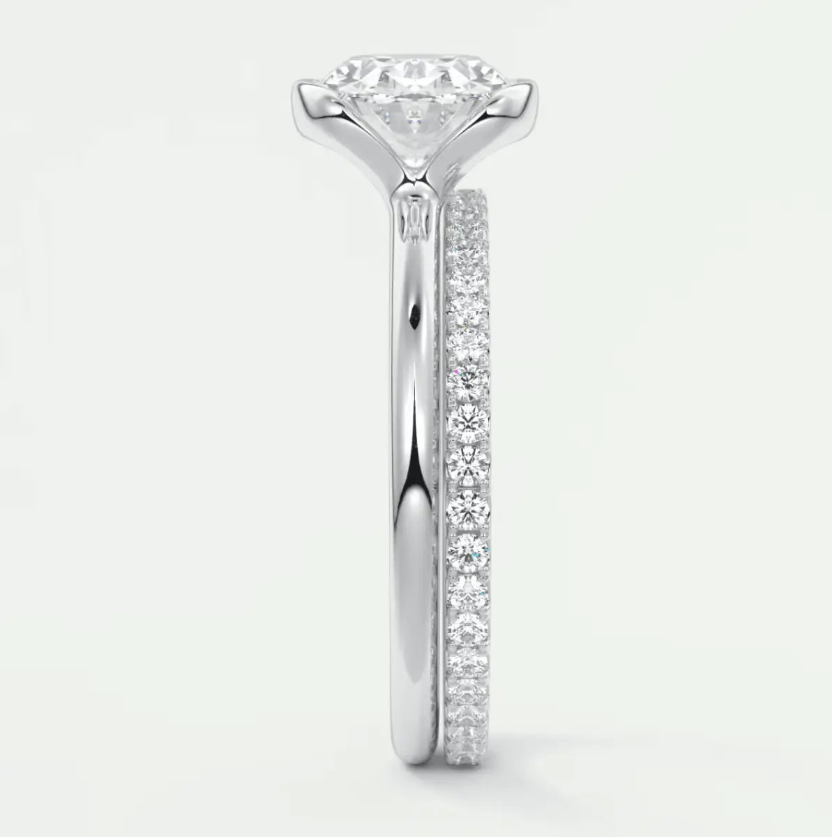 18k white gold diamond engagement ring with a round brilliant cut center stone and pavé set diamonds on the band.