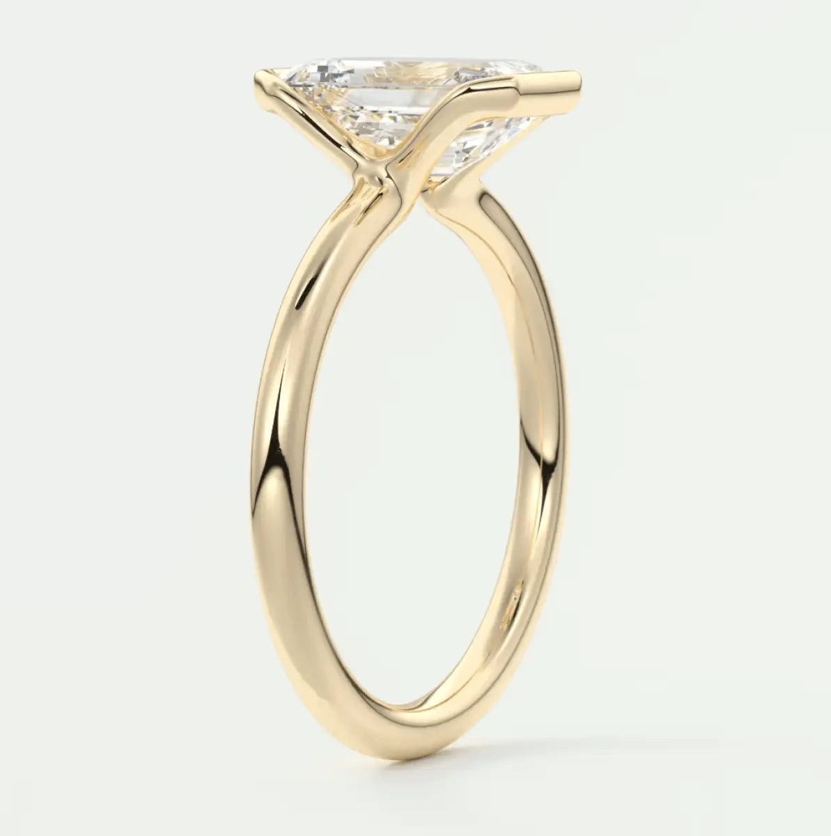 18-karat yellow gold engagement ring with a princess-cut diamond.