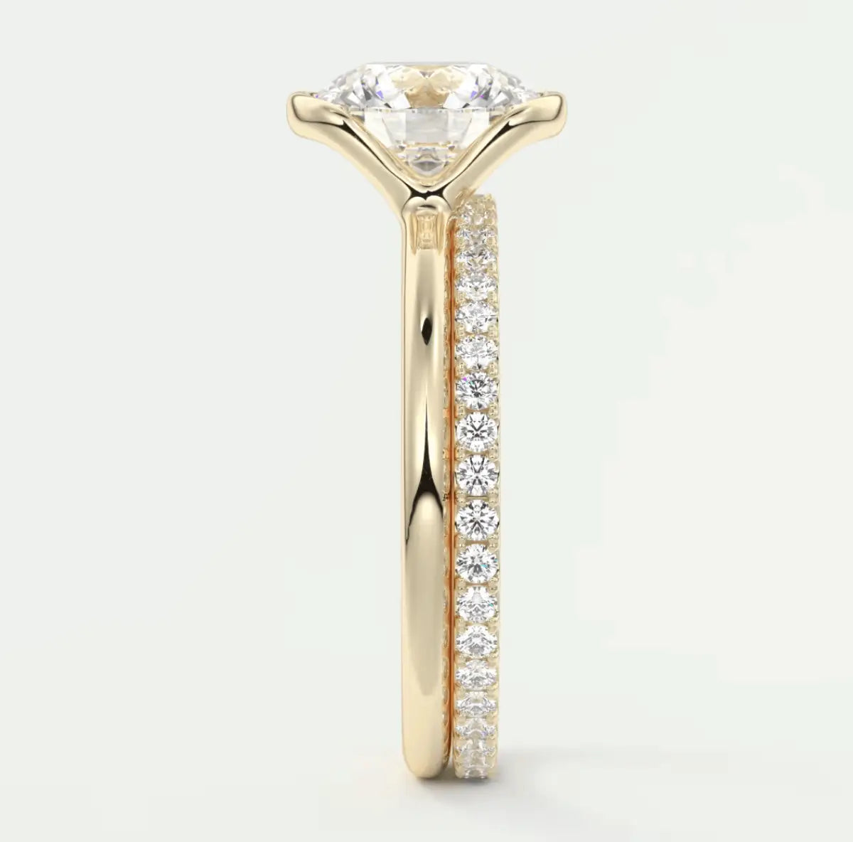 18k yellow gold engagement ring with a round diamond center and pave set diamonds on the band.