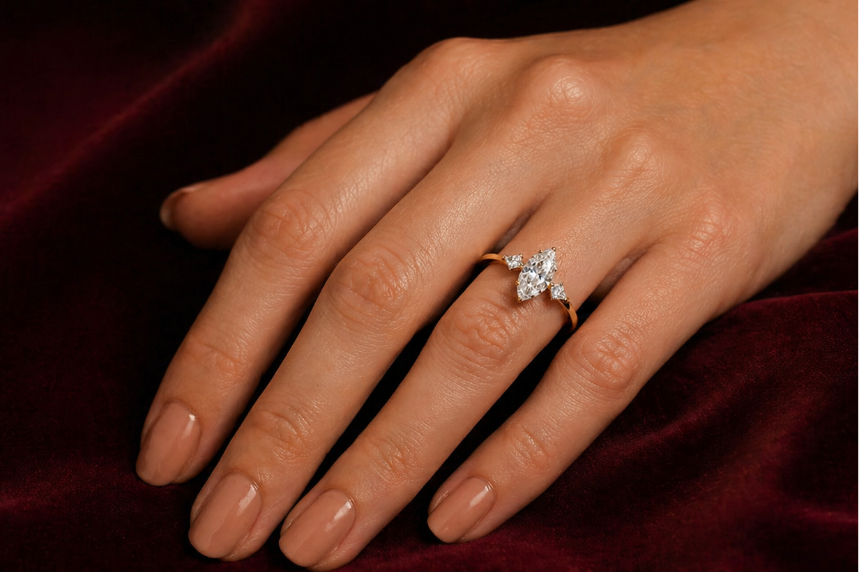 Hand wearing a diamond ring on a dark background