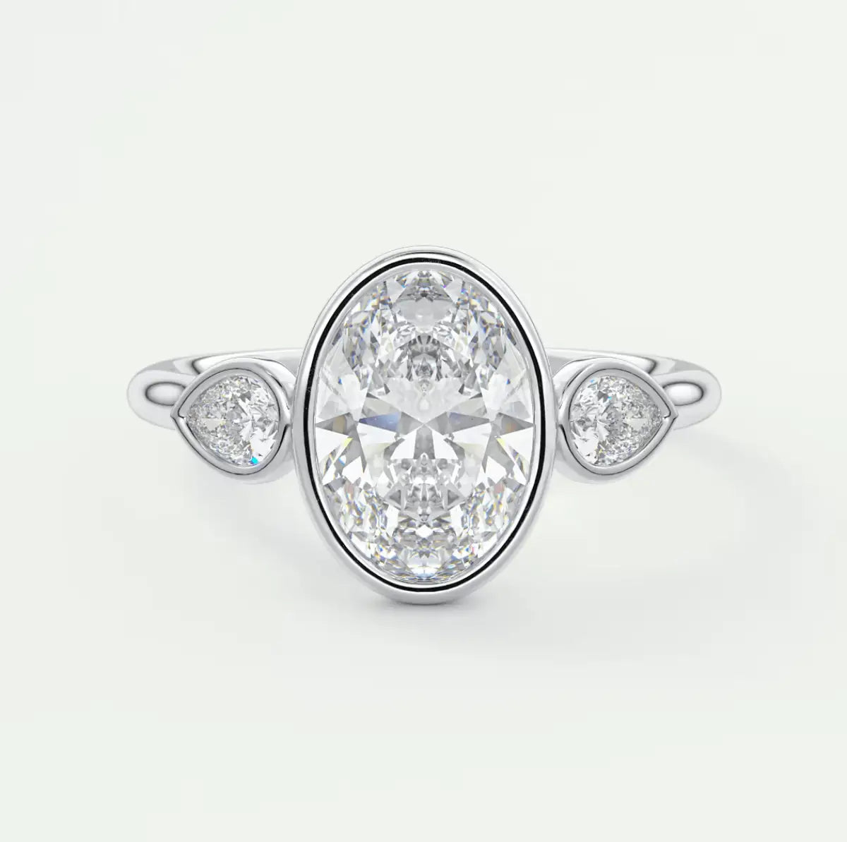 18k white gold diamond engagement ring with an oval-cut center stone and two smaller round diamonds on either side.