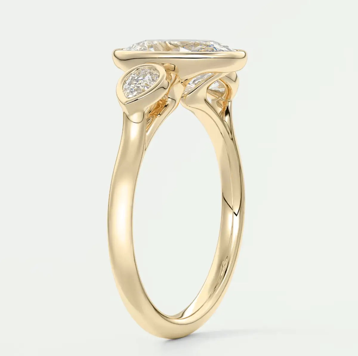 18k yellow gold engagement ring with a princess cut diamond and two smaller diamonds on either side.