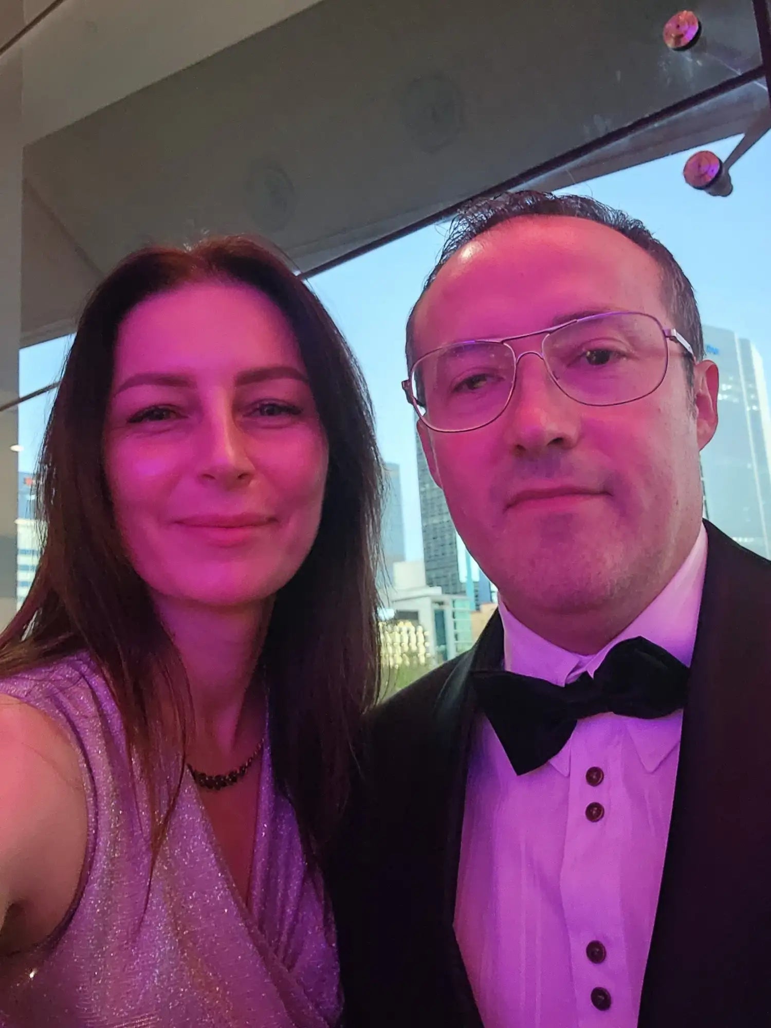 Two people posing for a selfie in front of a reflective surface.