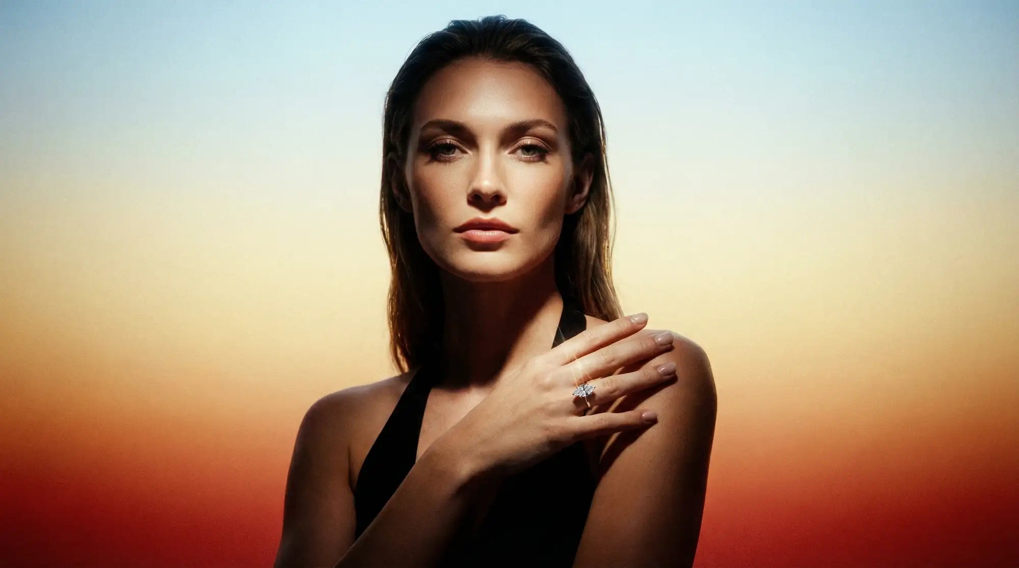 Woman with hand on shoulder against a gradient background