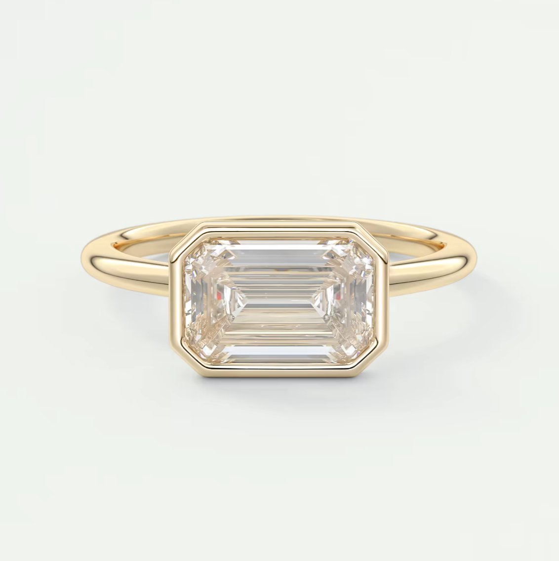 East West Emerald Bezel Engagement Ring
