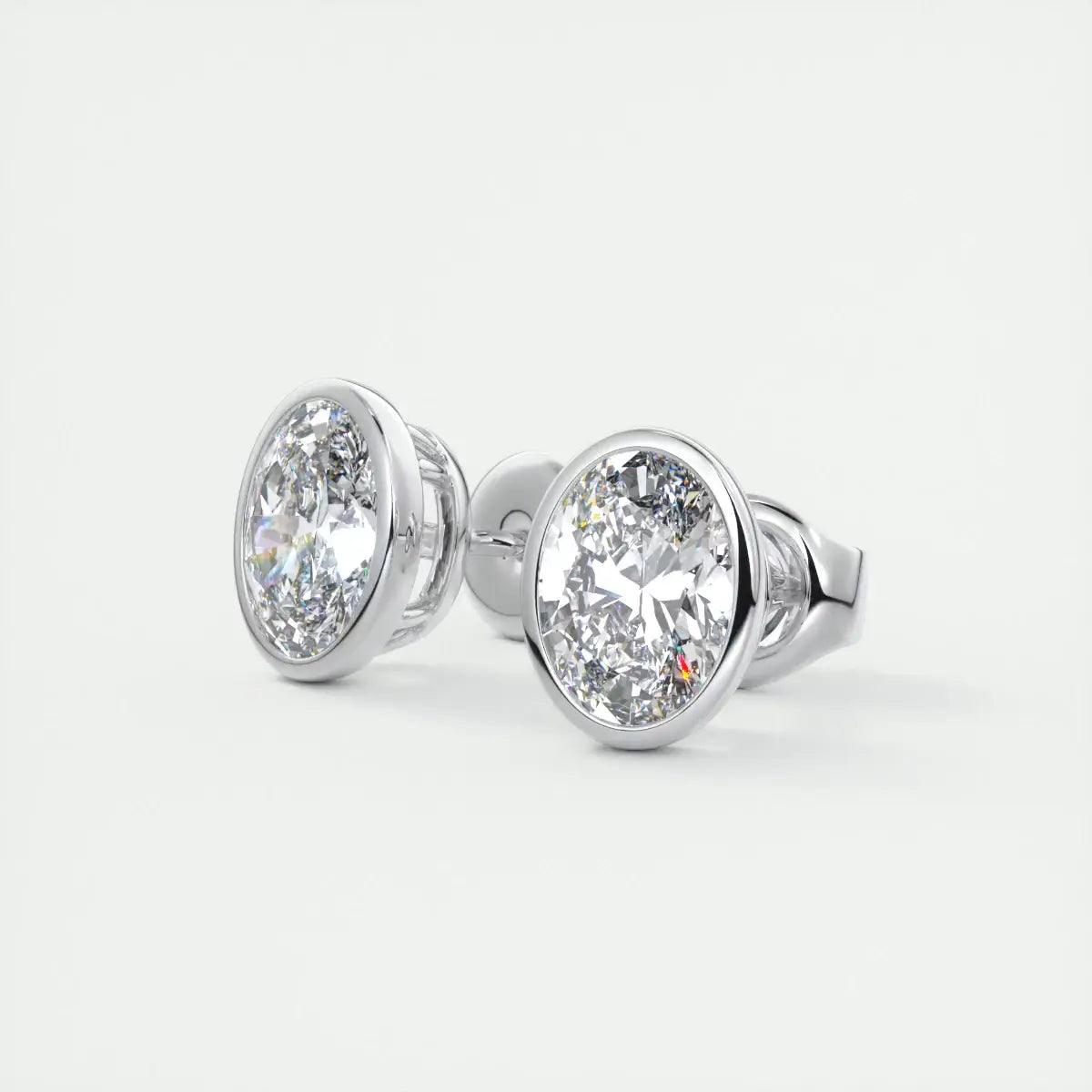 White gold oval diamond stud earrings with bezel setting.