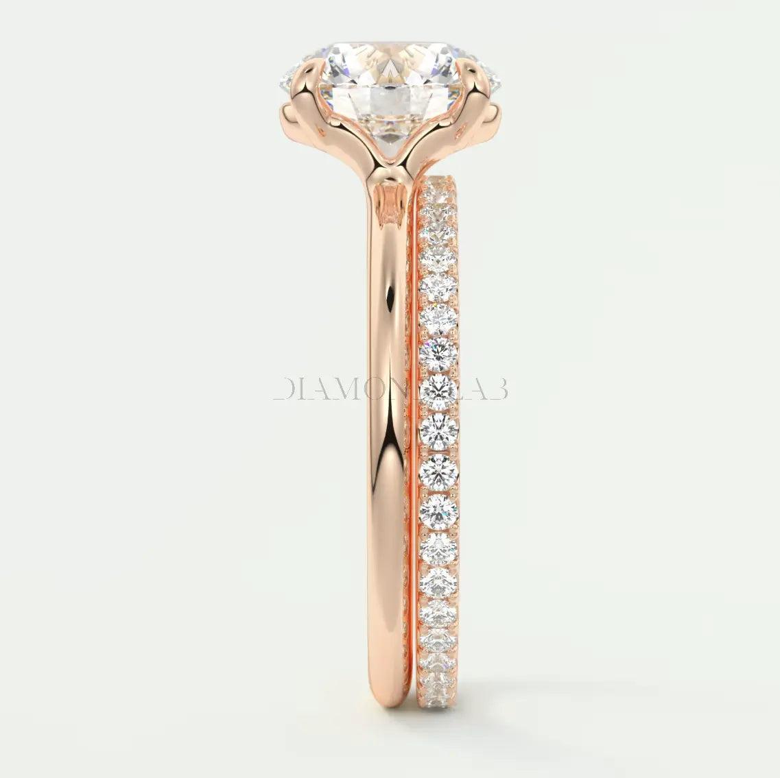 18k rose gold engagement ring with a round diamond center and pavé set diamonds on the band.