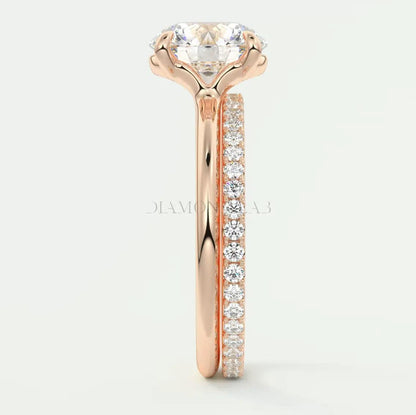 18k rose gold engagement ring with a round diamond center and pavé set diamonds on the band.