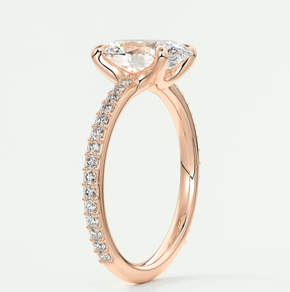 18k rose gold diamond engagement ring with a marquise-cut center stone and pave set diamonds on the band.