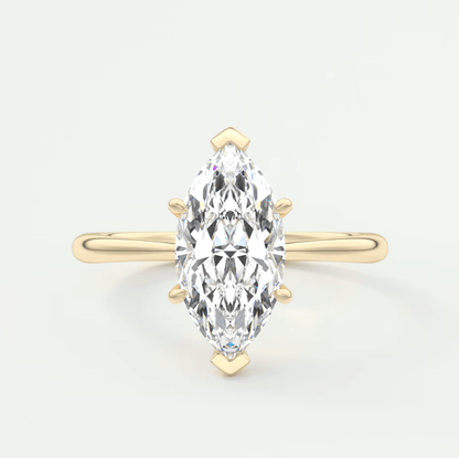 Gold marquise-cut diamond engagement ring with four prongs and small blue accents.