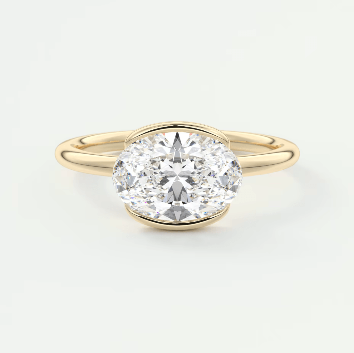 18k yellow gold oval diamond engagement ring with a bezel setting.