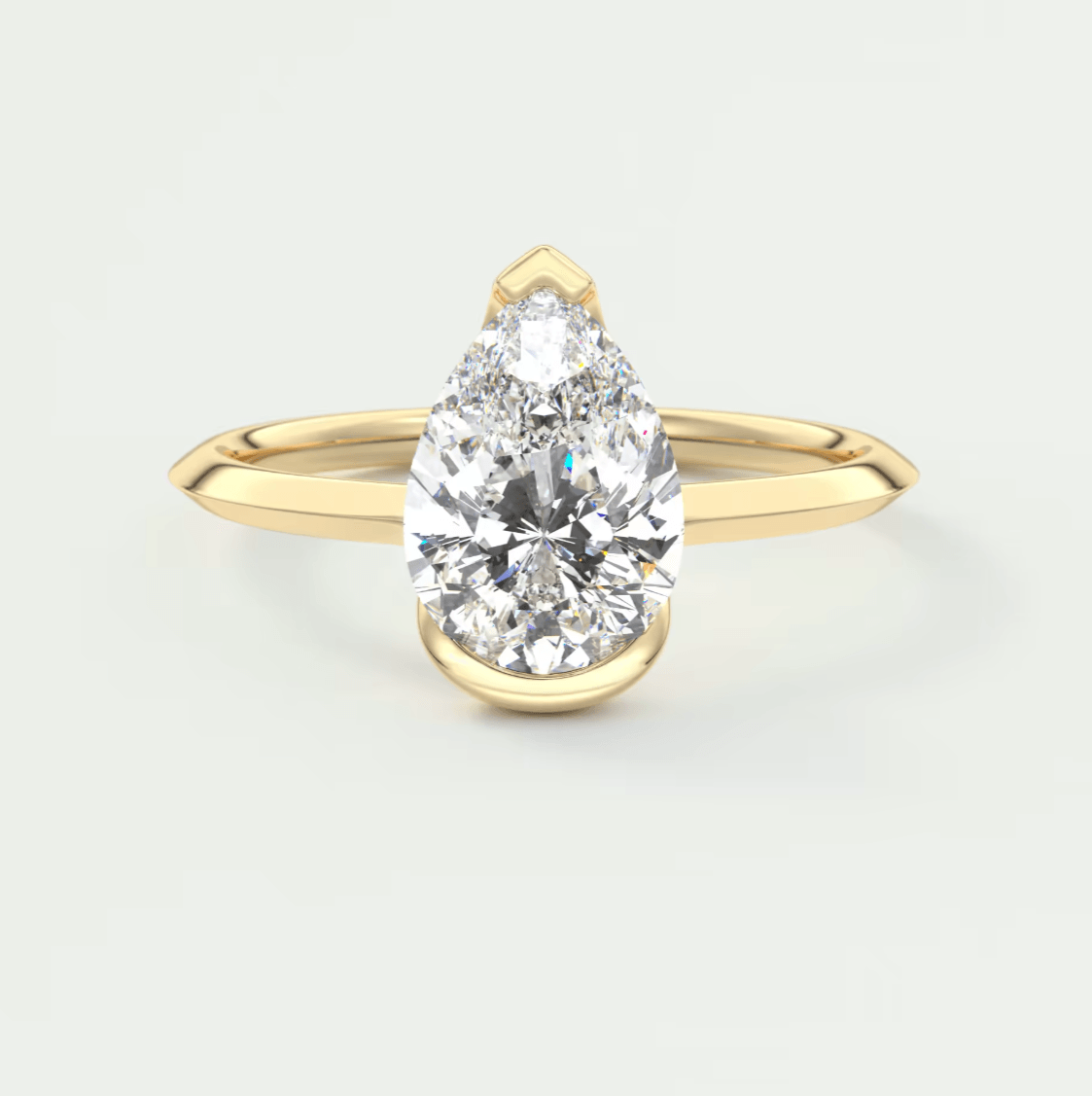 Pear-shaped diamond engagement ring with yellow gold band, elegant design.