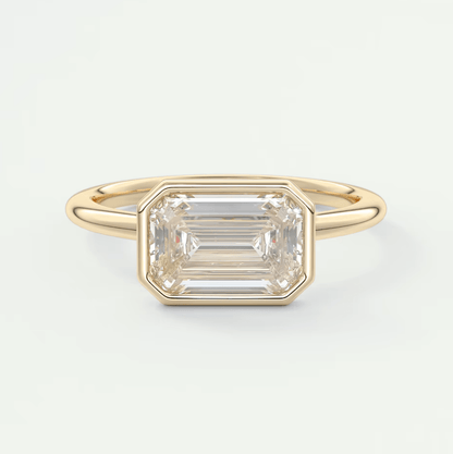 18-karat yellow gold emerald-cut diamond ring with a bezel setting.