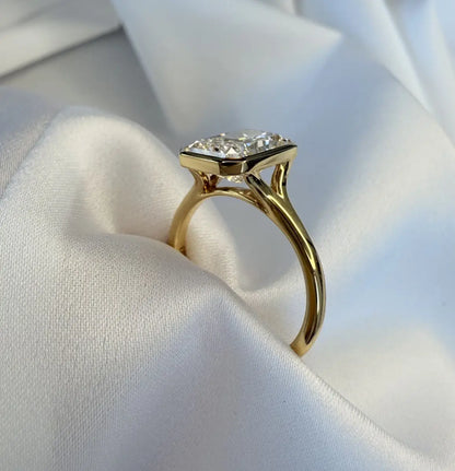 Gold ring with a diamond on a white fabric background
