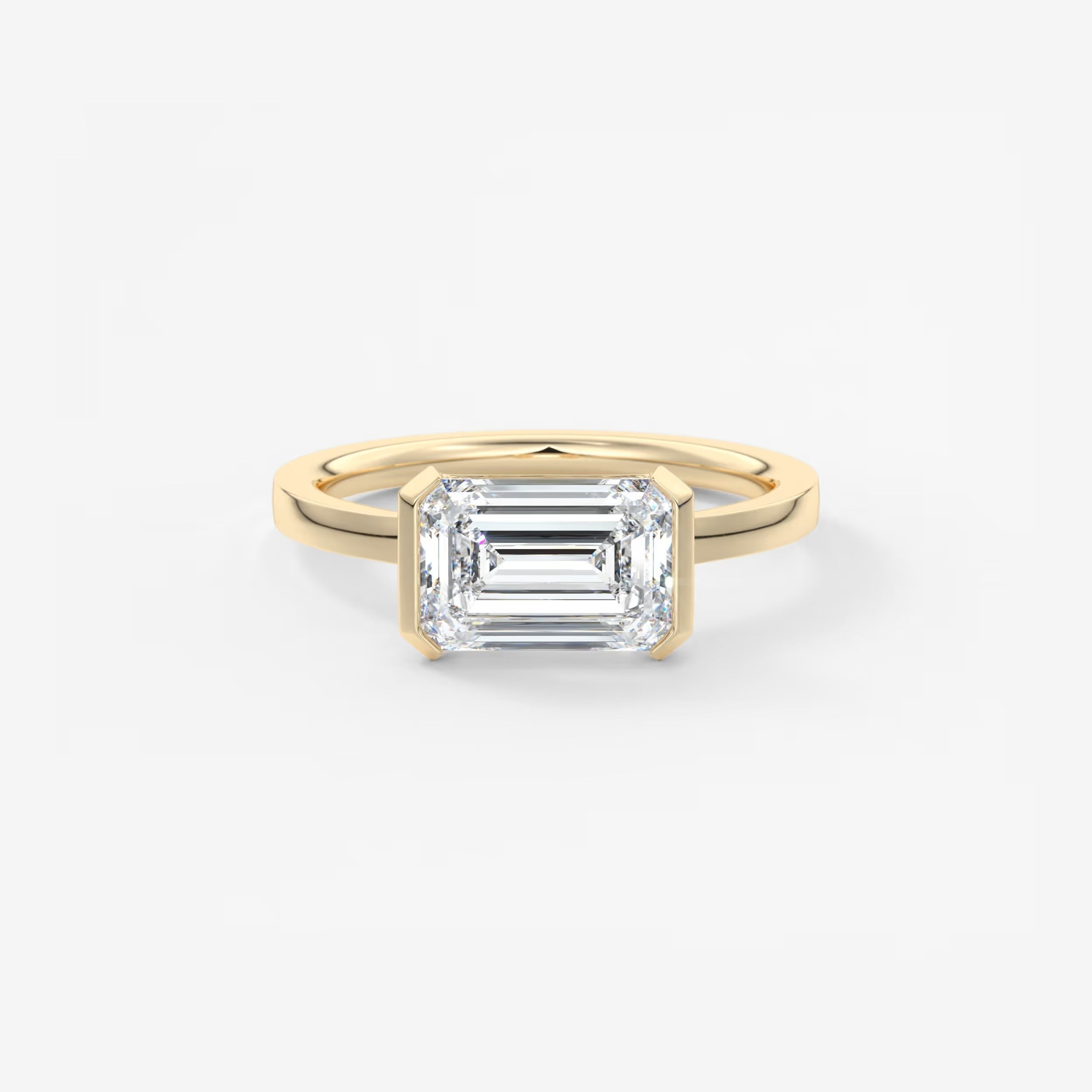 Gold ring with a rectangular diamond on a white background