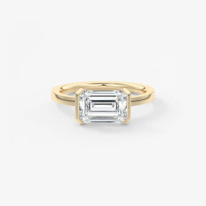 Gold ring with a rectangular diamond on a white background