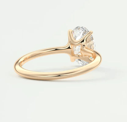 18-karat gold solitaire diamond engagement ring with a cushion-cut gemstone.