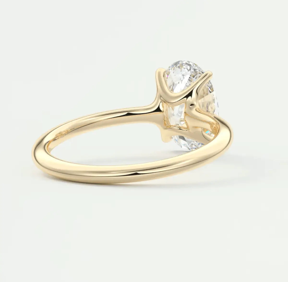 18-karat yellow gold engagement ring with a round diamond center stone and two smaller diamonds on either side.