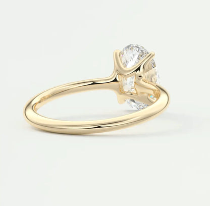 18-karat yellow gold engagement ring with a round diamond center stone and two smaller diamonds on either side.