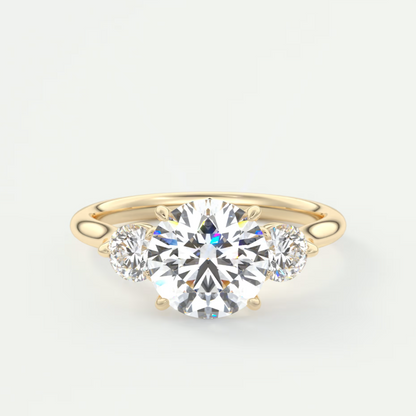 Gold ring with a large central diamond and two smaller diamonds on a white background
