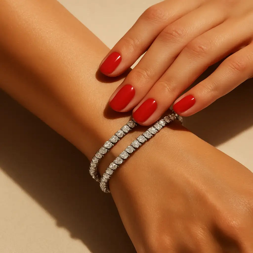 Close-up of a hand wearing a diamond bracelet on a beige background