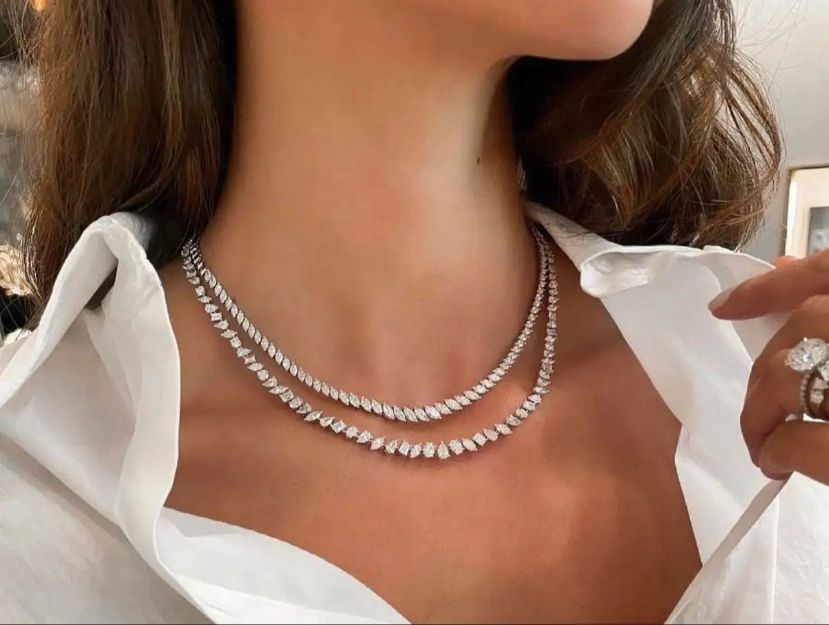 A double-strand diamond tennis necklace in a sleek, silver-toned metal setting.